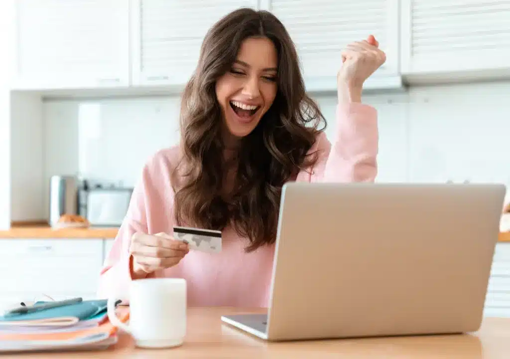 Joven feliz mostrando aprobación de préstamo de 600 euros con 0% de interés en su primera solicitud